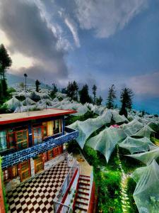 a bunch of green buildings with nets around them at Sneh by Daisey in Cheog