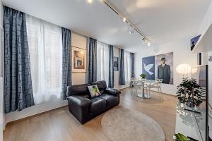 a living room with a black leather chair and a table at Surreal cocoon in Brussels center in Mellet