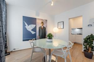 a dining room with a glass table and chairs at Surreal cocoon in Brussels center in Mellet