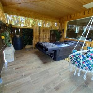 une terrasse couverte avec un hamac et un bain à remous dans l'établissement Country Cottage & Spa, à Labalme