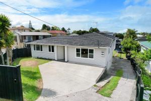 a white house with a driveway in a yard at Relax near Auckland city & enjoy in Auckland
