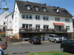 Ein Mann steht vor einem großen weißen Haus. in der Unterkunft Haus Waldeck in Zell an der Mosel