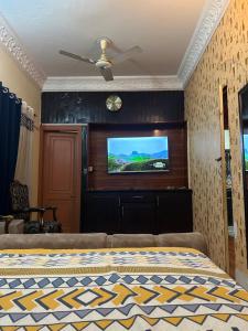 een slaapkamer met een flatscreen-tv aan de muur bij Ayyan Cottage F 10 in Islamabad