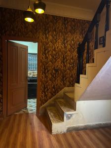 een gang met trap en een deur met een bakstenen muur bij Ayyan Cottage F 10 in Islamabad