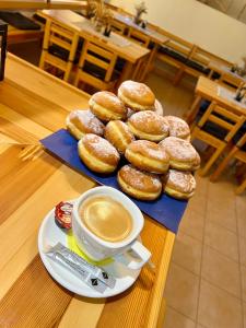 a table with a plate of donuts and a cup of coffee at Bořikovský Dvůr in Litovany +38 photos