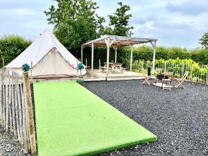 a tent with a green lawn in a yard at Carrowmena School House & Glamping in Limavady