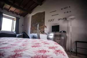a bedroom with a bed and a desk with a television at Morelliana4Rooms in Scansano