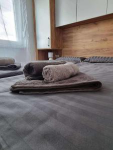 three towels are laying on a bed in a room at Bella LUX in Modriča