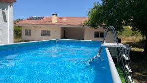 a swimming pool with a slide in front of a house at LA MINA Alojamiento en plena naturaleza in Garganta de los Montes