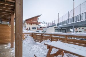 a snow covered porch with a wooden fence and a bench at Alpe d'Huez Houses - Chez J et J - Quartz - 1 chambre ski au pied via Alpe Express in L'Alpe-d'Huez