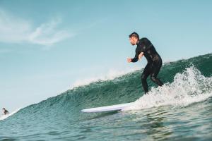 a man riding a wave on a surfboard in the ocean at Sukha surf lodge in Lit-et-Mixe
