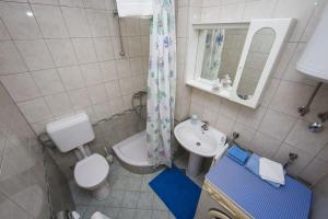 a bathroom with a toilet a sink and a mirror at Apartment Karla&Nella in Stobreč