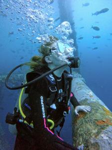 a woman with a camera is underwater next to a wall at Kimbas Bungalows Mancora in Máncora
