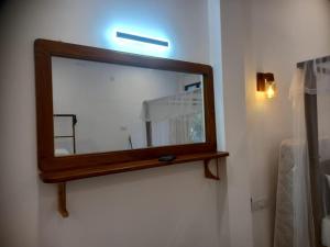 a mirror on the wall of a bathroom at Cozy Cottage in Ahangama