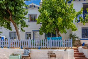 una cerca blanca frente a una casa en Blue Castle GuestHouse, en Málaga