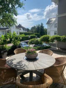 a wooden table with chairs and a pot of flowers on it at Mølleråsen Apartment in Sandefjord
