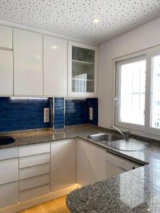 a kitchen with white cabinets and a sink at Wohnung Rio in Calpe