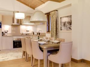 une cuisine et une salle à manger avec une table et des chaises en bois dans l'établissement Luxueux Duplex à Courchevel Village, Proche Pistes et Commerces, avec Parking et Accès Fitness - FR-1-562-22, à Courchevel