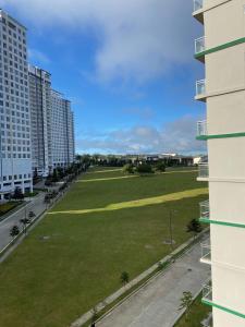 eine große Wiese zwischen zwei hohen Gebäuden in der Unterkunft JFC Inspired Stays PH - Wind Residences Tagaytay in Upli
