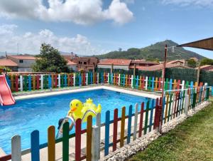 a colorful fence around a pool with a toy in it at A Finquiña in Salcidos