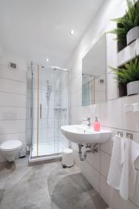 a white bathroom with a sink and a shower at Central Studio Near Main Train Station & Old City Hall in Wuppertal