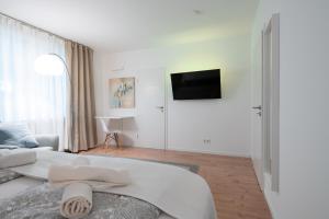 a white room with a bed and a tv at Central Studio Near Main Train Station & Old City Hall in Wuppertal