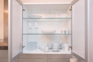 a cupboard filled with dishes and cups and plates at Central Studio Near Main Train Station & Old City Hall in Wuppertal +13 photos