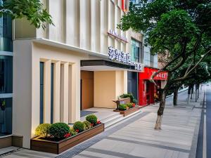 a sidewalk in front of a building with a tree at 重庆莎霏酒店大渡口店 in Chongqing