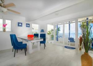 a dining room with a table and blue chairs at Oceanfront Bungalow Cable Beach 2 Bedroom in Macbride