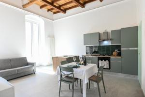 ビシェーリエにあるL'albero della vitaのテーブルと椅子のあるキッチンとリビングルーム