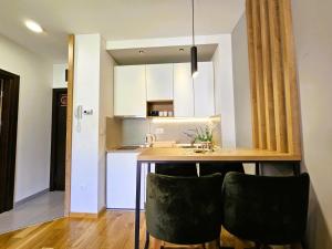 a kitchen with a table and some black chairs at Chilltorium Zlatibor in Zlatibor