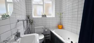 a bathroom with a tub and a toilet and a sink at Double Bed at Cozy Hailsham in London +32 photos