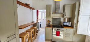a kitchen with white cabinets and a stove top oven at Double Bed at Cozy Hailsham in London