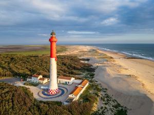 an aerial view of a lighthouse next to a beach at Lisière Hébergements - Casa Mouette Mouette in La Tremblade