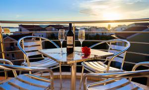 a table with a bottle of wine and two chairs at Villa Dragic in Brodarica