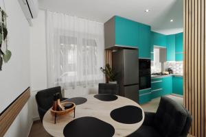 a kitchen with a table and some blue cabinets at Kilian Suite in Miskolc