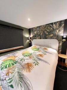 a bedroom with a bed with a floral bedspread at Studio with sauna in Meise