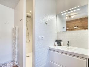 a white bathroom with a sink and a mirror at Val Thorens : Appart moderne 6 pers, accès pistes, parking, WIFI - FR-1-640-78 in Val Thorens
