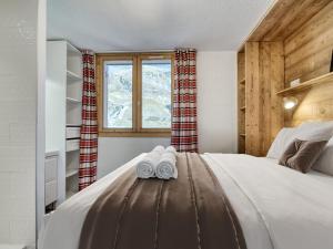 a bedroom with a bed with two slippers on it at Val Thorens : Appart moderne 6 pers, accès pistes, parking, WIFI - FR-1-640-78 in Val Thorens