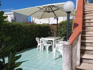 a table and chairs with an umbrella on a patio at Casa sul mare vicino Diamante in Belvedere Marittimo