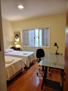 a room with two beds and a desk and a window at Casa em Condominio Central in Campinas +21 photos