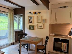 a kitchen with a table and chairs in a room at Cozy appartement style chalet in Torgon