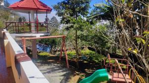 Un parque infantil en un jardín con un tobogán de agua. en PEARS GARDEN HILL VIEW SUITE, en Kodaikanal