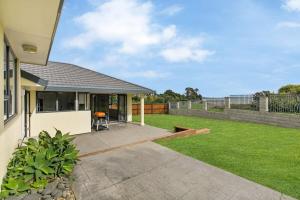 a backyard of a house with a lawn at Stunning Sea View Home Very near to AKL Airport in Auckland