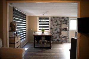 a dining room with a table and a window at Ruim en sfeervol chalet aan de rand van het bos in IJhorst +8 photos
