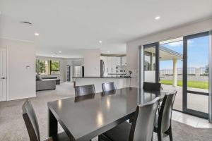 a dining room and kitchen with a table and chairs at Stunning Sea View Home Very near to AKL Airport in Auckland