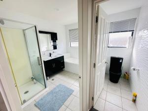 a bathroom with a shower and a sink at Stunning Sea View Home Very near to AKL Airport in Auckland +20 photos