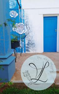 a sign in front of a building with a blue door at Von Loë Huizen in Fauresmith