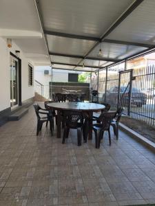 Un grupo de mesas y sillas en un patio. en Casa Popa, en Costinesti