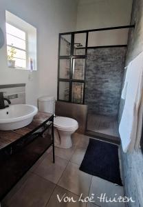a bathroom with a tub and a toilet and a sink at Von Loë Huizen in Fauresmith